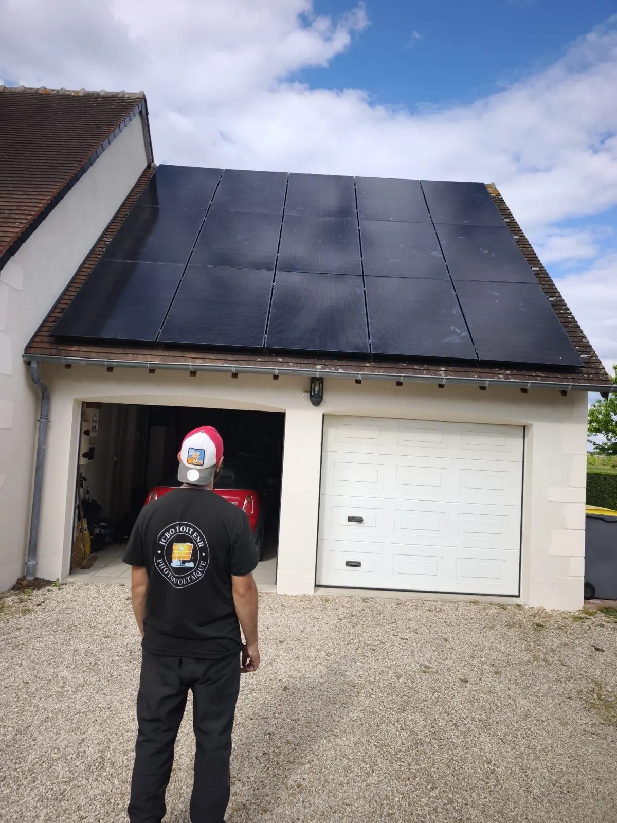 Technicien JCBO Toit ENR devant une toiture équipée de 16 panneaux full black