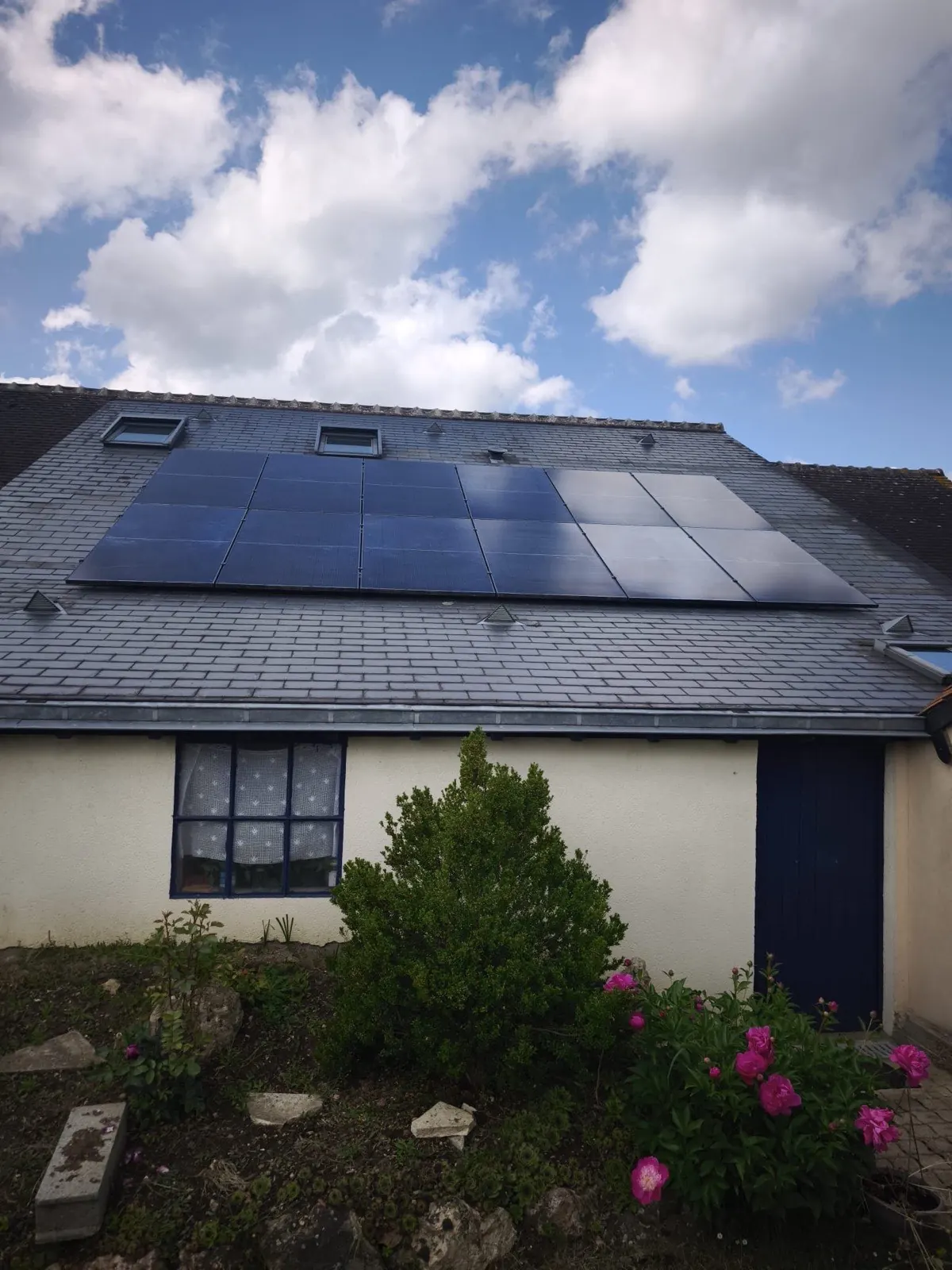 Panneaux solaires sur toiture en ardoise d'une maison de caractère