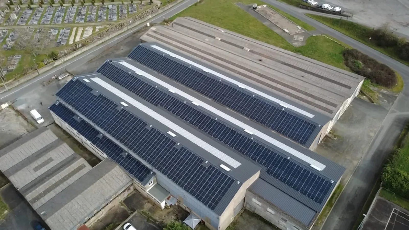 Vue aérienne d'un bâtiment industriel en bac acier couvert de panneaux photovoltaïques