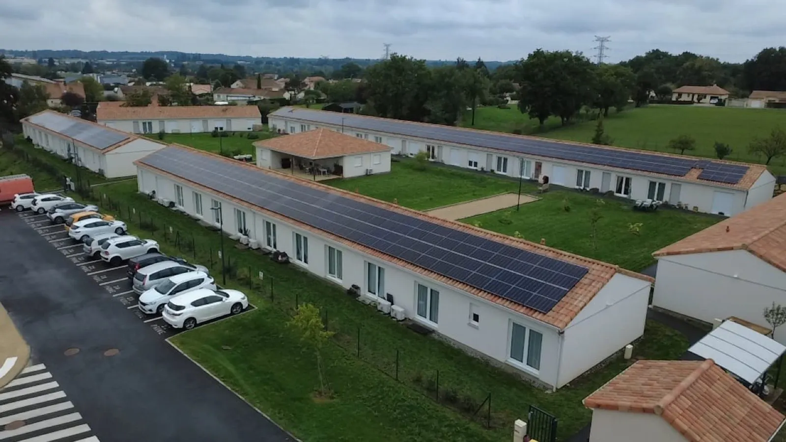 Vue aérienne d'une résidence collective équipée de champs de panneaux solaires
