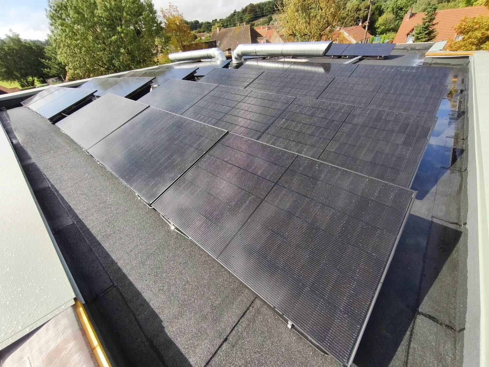 Toit terrasse équipé de panneaux solaires inclinés sur châssis lestés