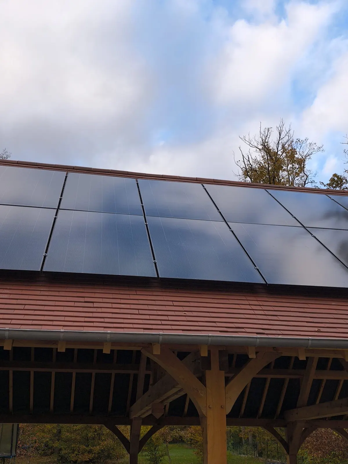 Panneaux solaires sur un préau à charpente bois traditionnelle en chêne