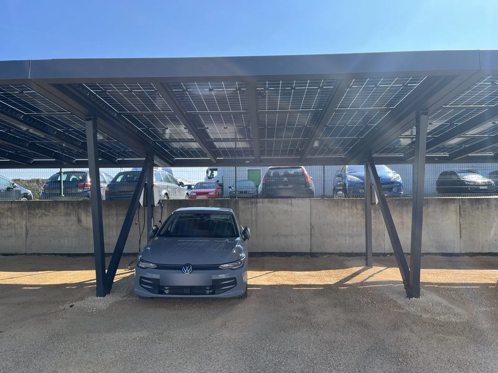 Sous-face translucide d'une ombrière photovoltaïque bi-verre avec bornes de recharge