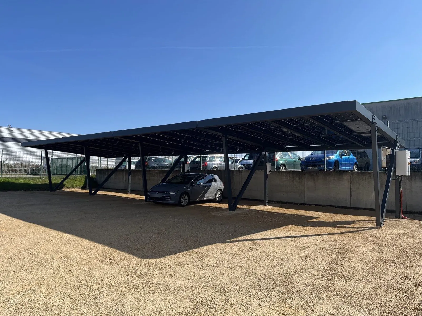 Ombrière de parking photovoltaïque avec bornes de recharge, réalisée par JCBO Toit ENR